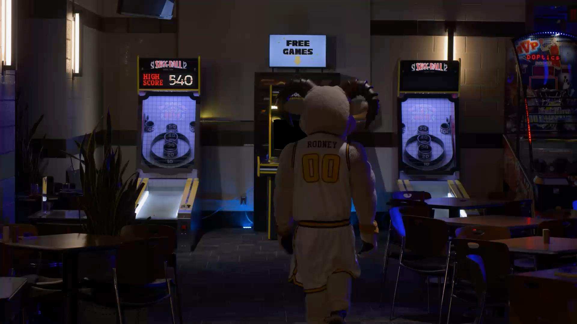 Rodney the ram approaches an arcade style gaming cabinet.