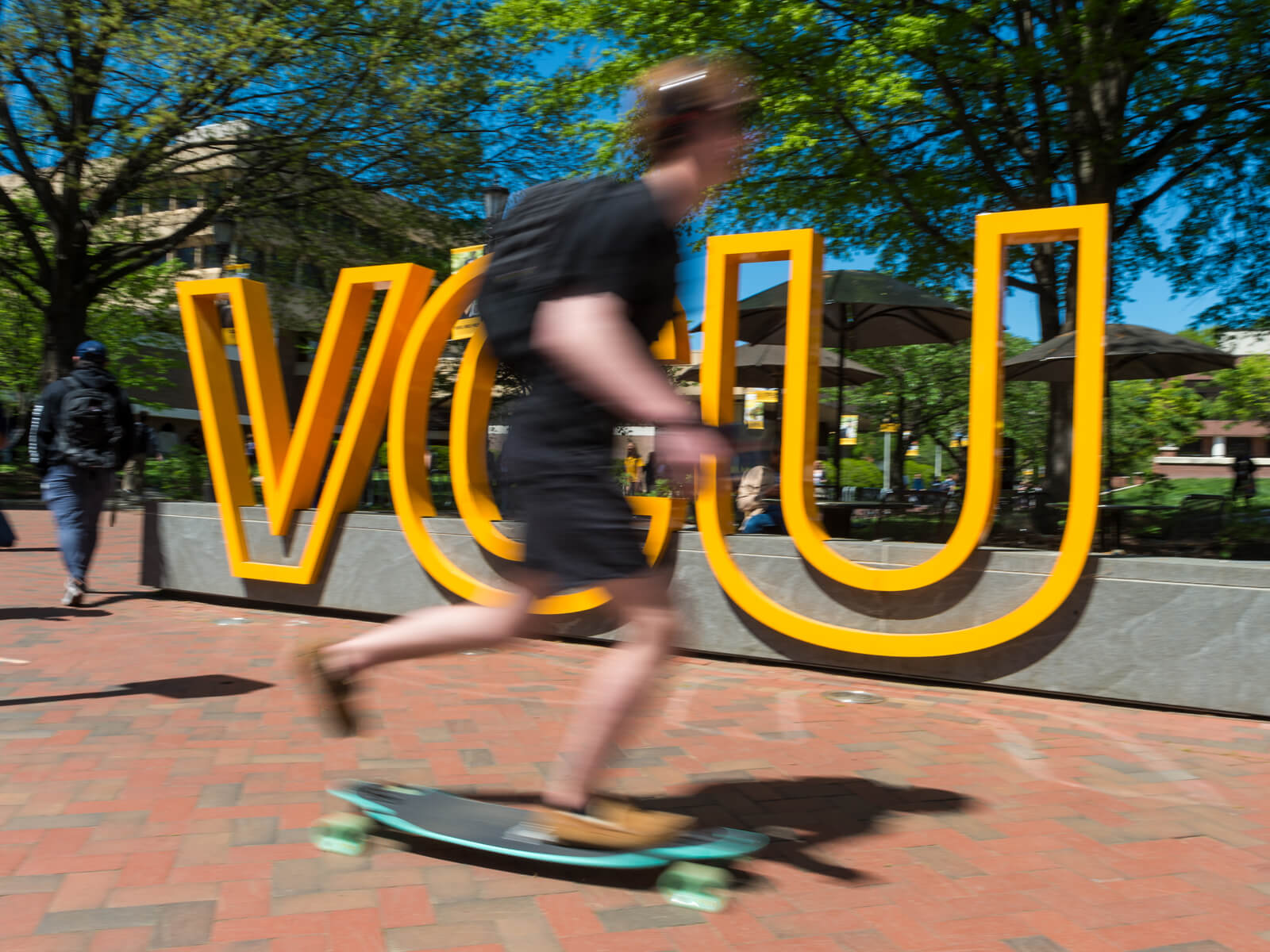 Student skateboarding on VCU campus