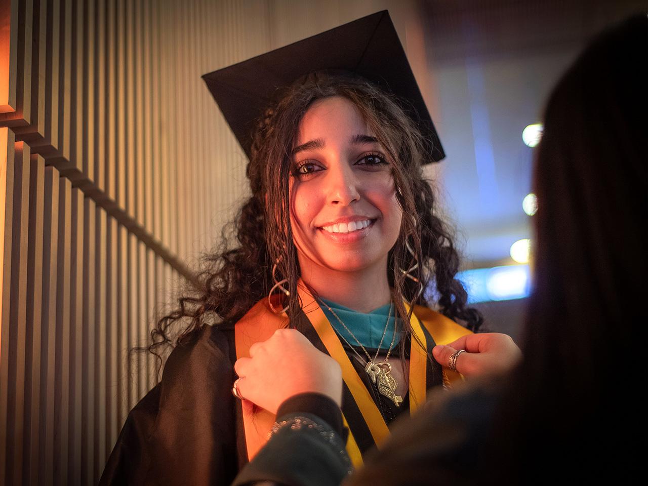Rawan Elbanna smiling wearing a graduation cap and gown