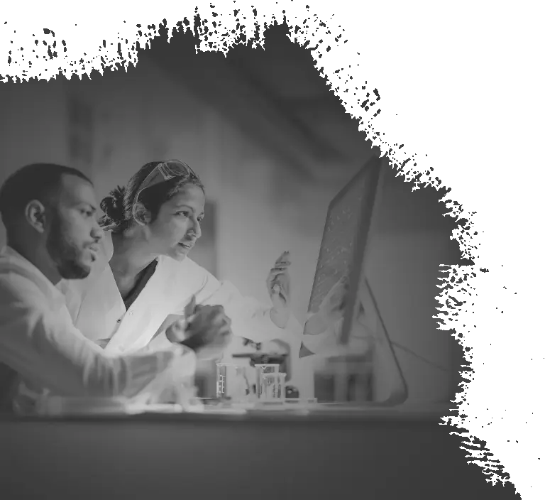 Two scientists examine data on a computer.