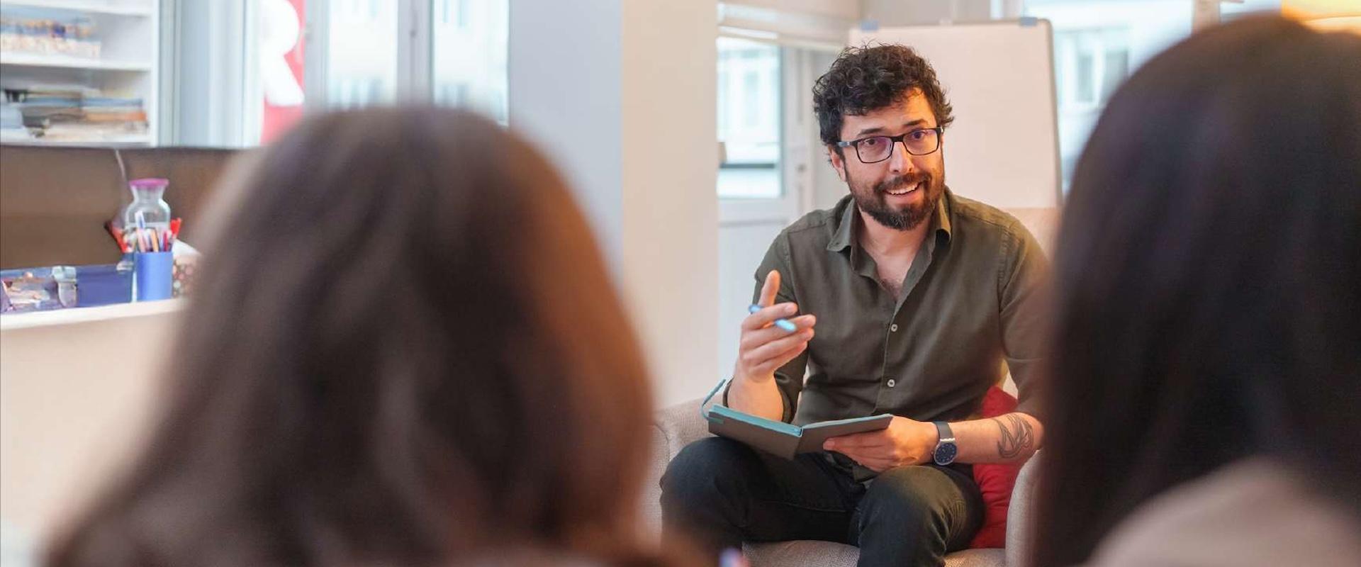 An individual meeting in a private setting with counselor taking notes
