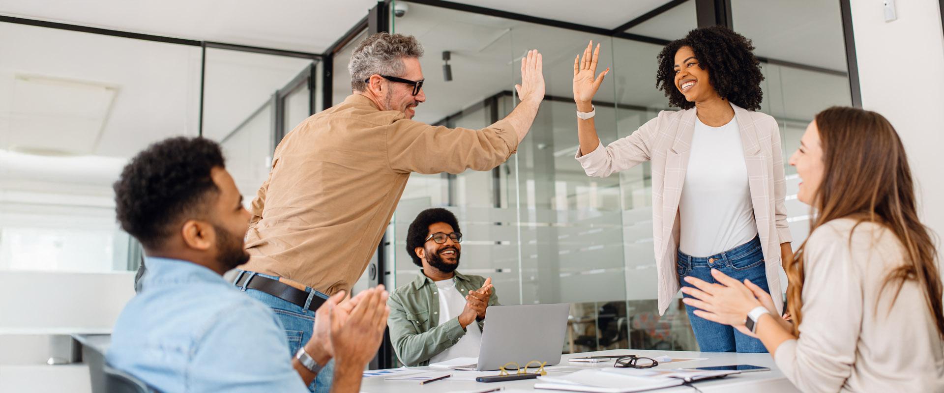 An educator writes on a white board while instructing a group of leaders and thinkers