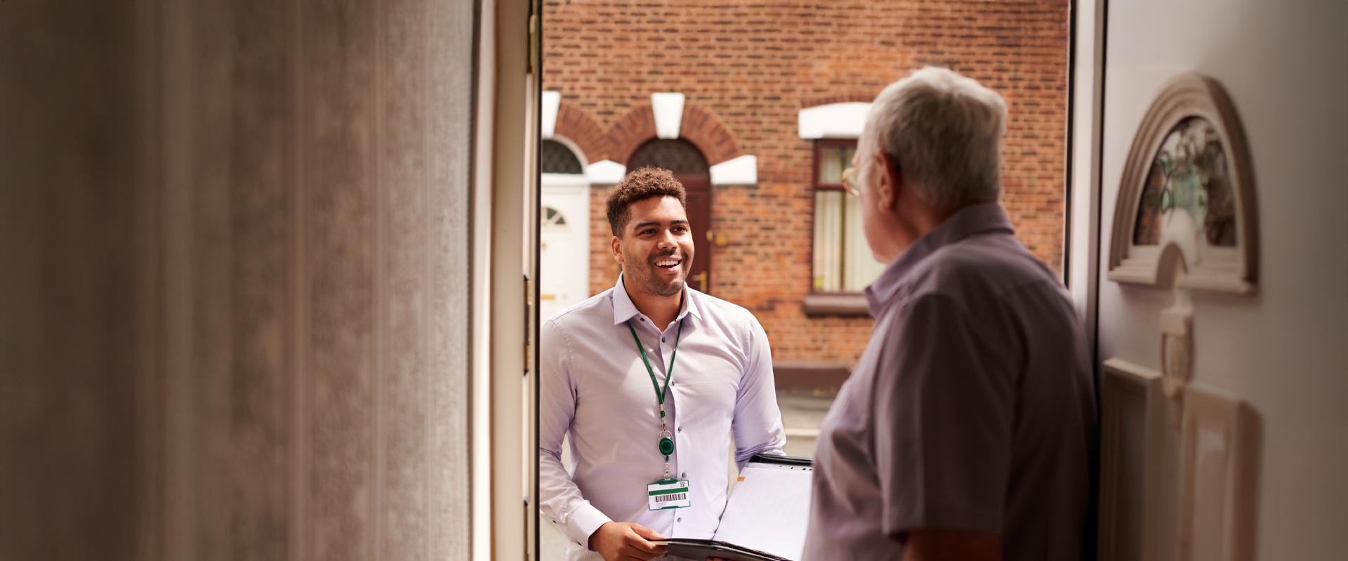 Patient opening the front door to let social worker in to their home.