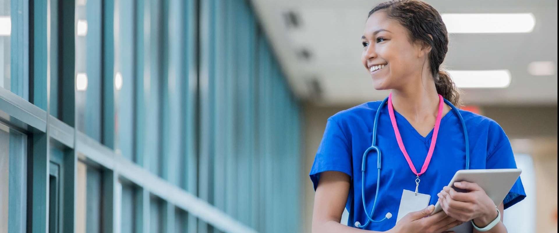 Smiling nurse walking down hallway.