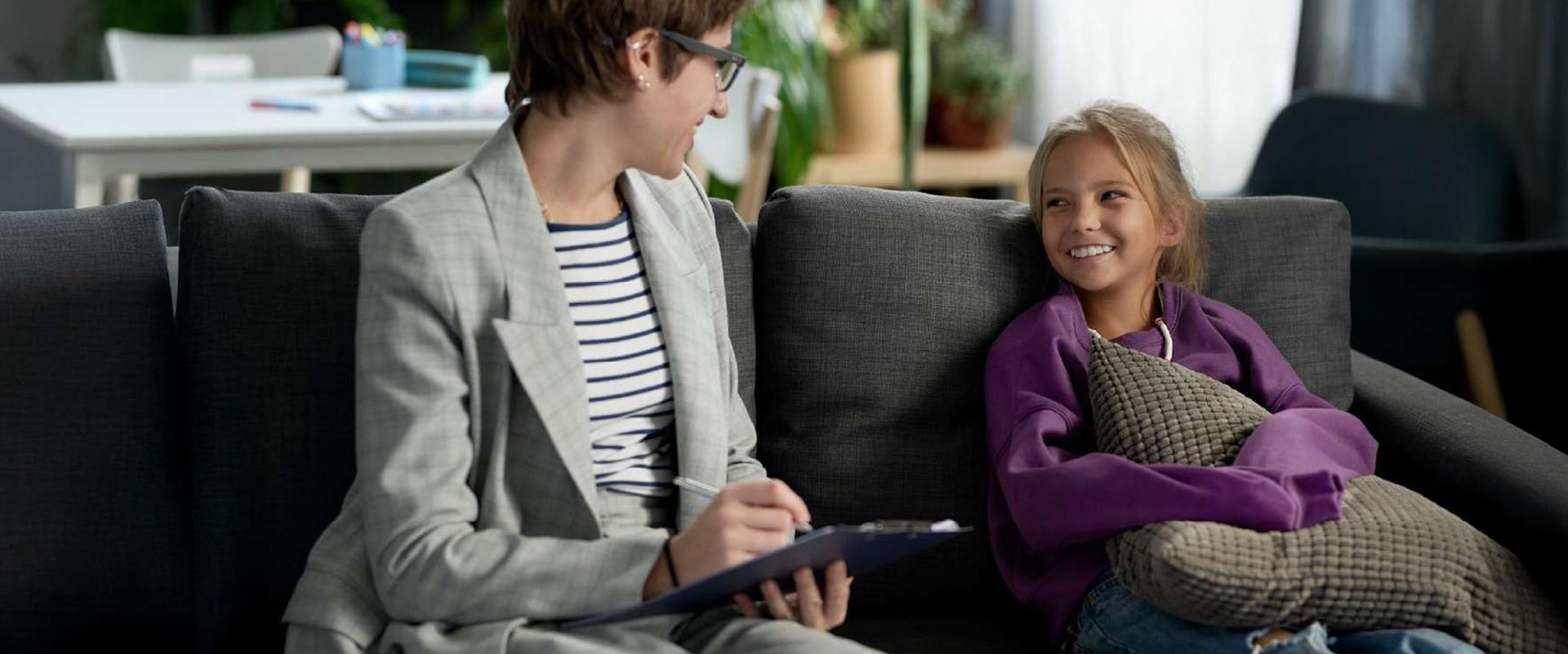 Social work professional listens and takes notes while meeting with a young person.