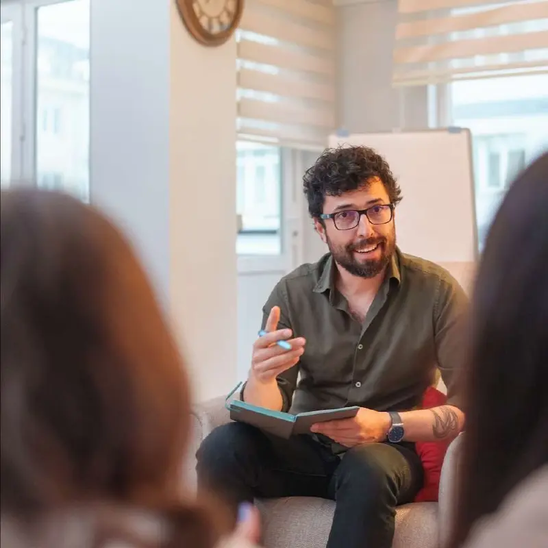 An individual meeting in a private setting with counselor taking notes