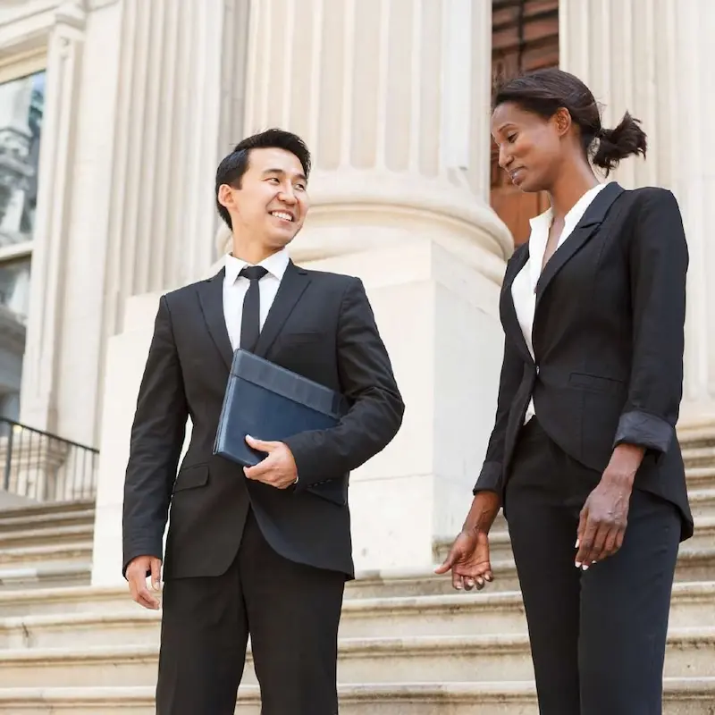 A group of two public policy experts in business suits walking on the steps of the Capitol.