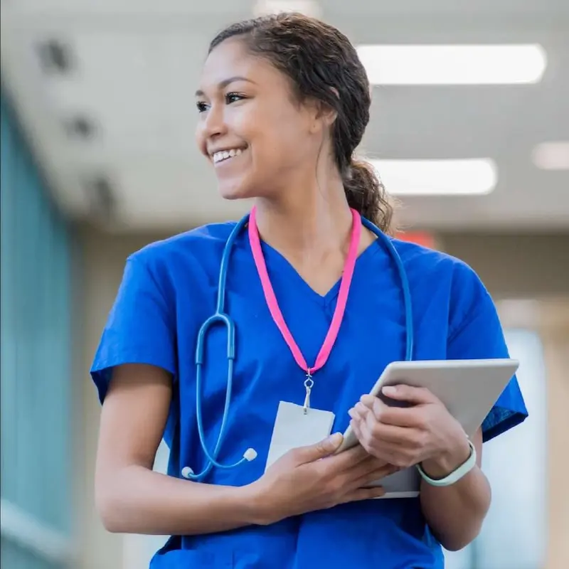 Smiling nurse walking down hallway.