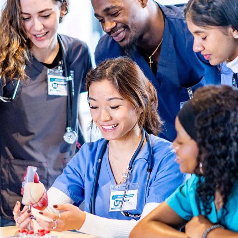 A group of nurses gathered to watch an instructor explain a concept.