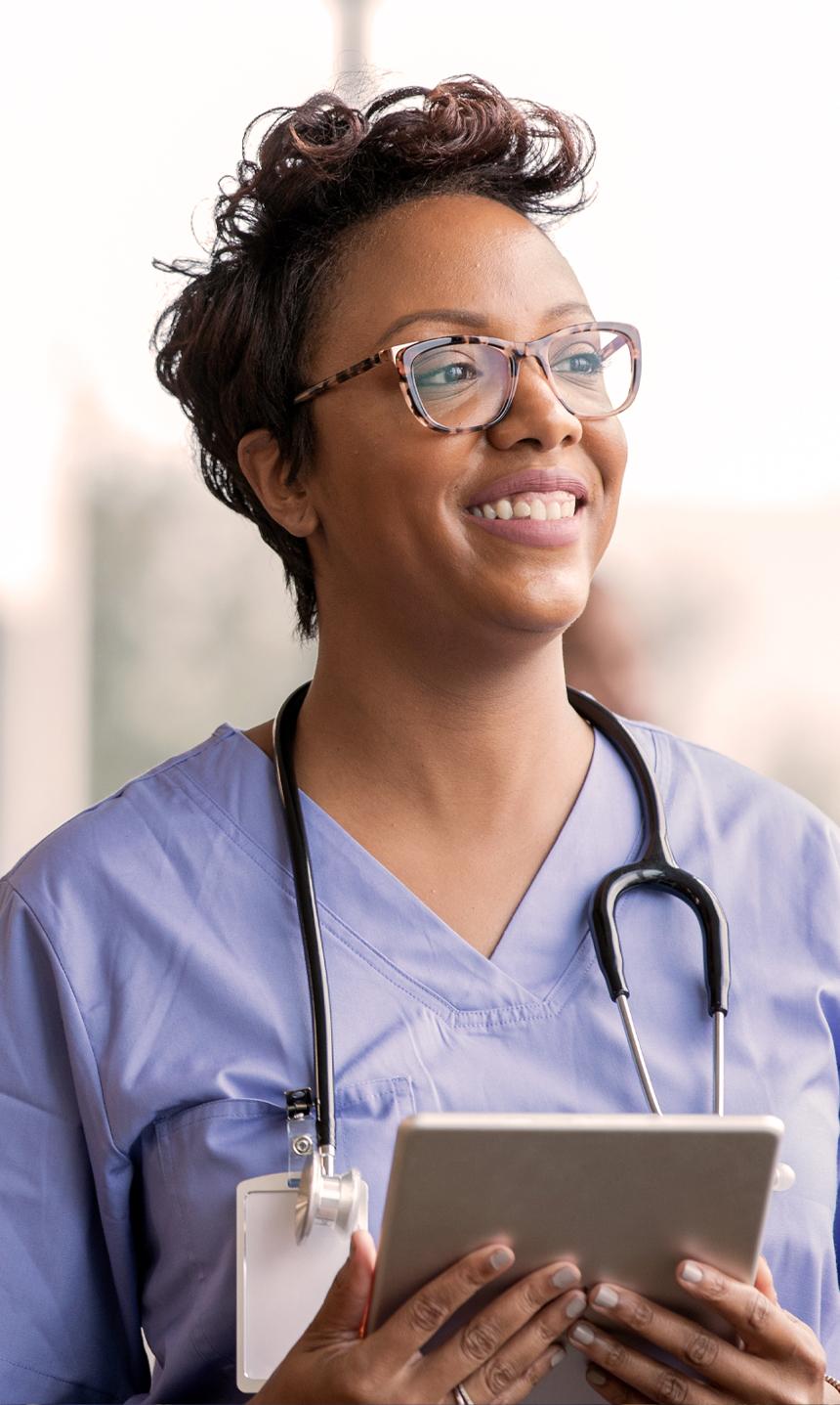 Person wearing medical scrubs wearing a stethoscope and smiling